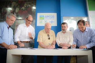 Carlos Sperotto (centro) no ato de assinatura da renovação da parceria (Foto: Fagner Almeida)